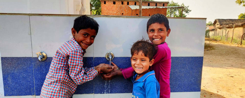 three-children-using-an-outside-water-tap